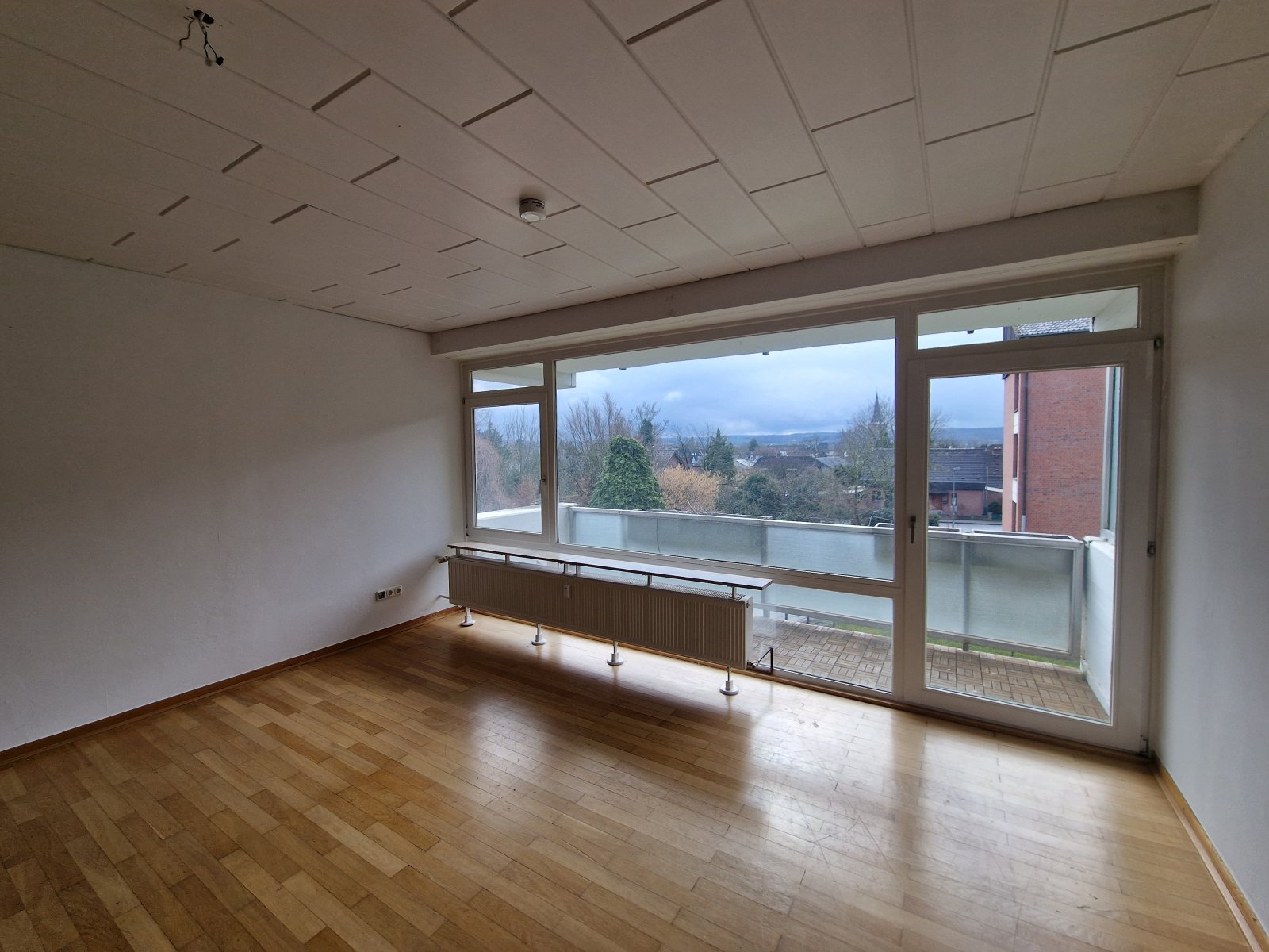 ein großzügiges Wohnzimmer mit Ausgang zum Balkon